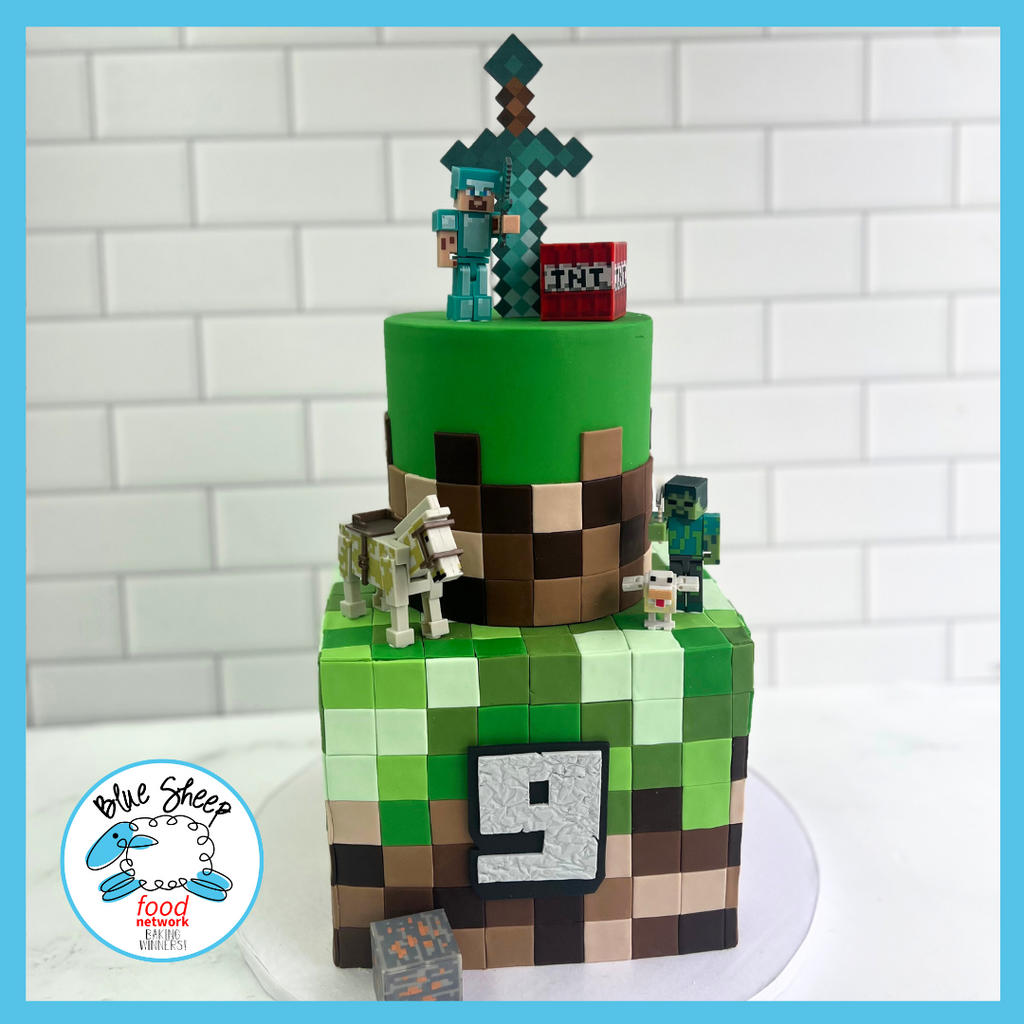 Block-themed birthday cake featuring pixelated characters, a figure with a sword on top, and game-inspired decorations, ideal for a gaming enthusiast's birthday.