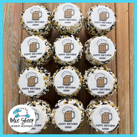 A dozen custom cupcakes with beer mug designs, celebrating "Adam," ideal for a beer enthusiast's birthday party.