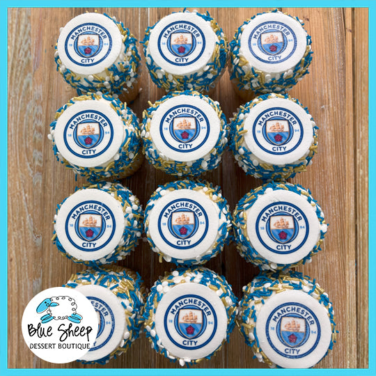 A set of Manchester City logo-themed custom cupcakes with blue and gold sprinkles, perfect for soccer fans.