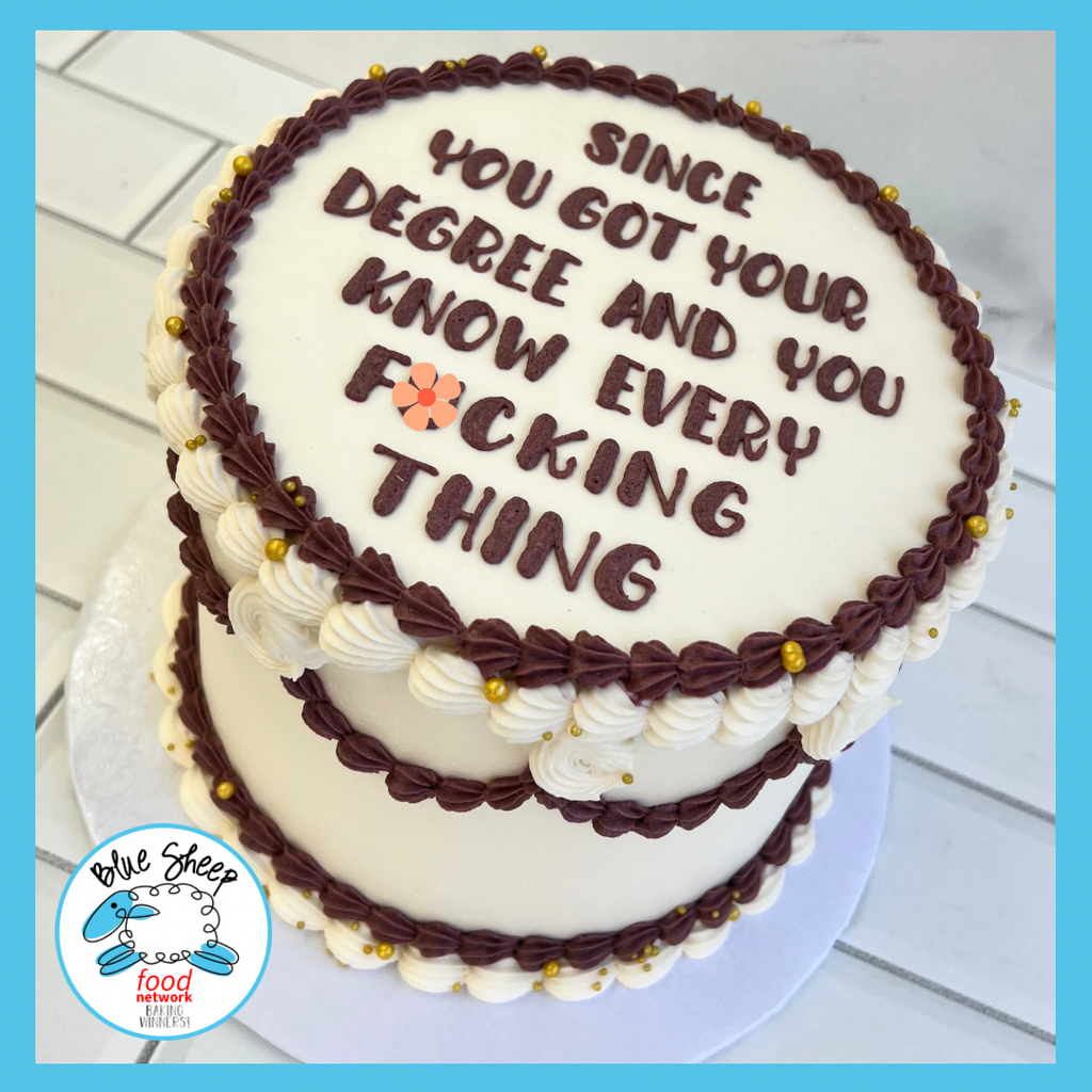 A humorous two-tiered graduation cake with a cheeky congratulatory message, decorated with white and chocolate frosting.