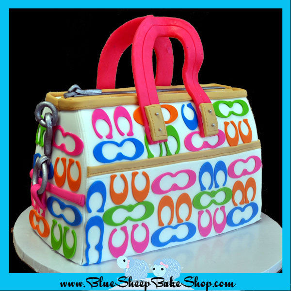 rainbow coach purse cake - cake carved to look like a purse with bright pink, orange, green, and blue c cutout's