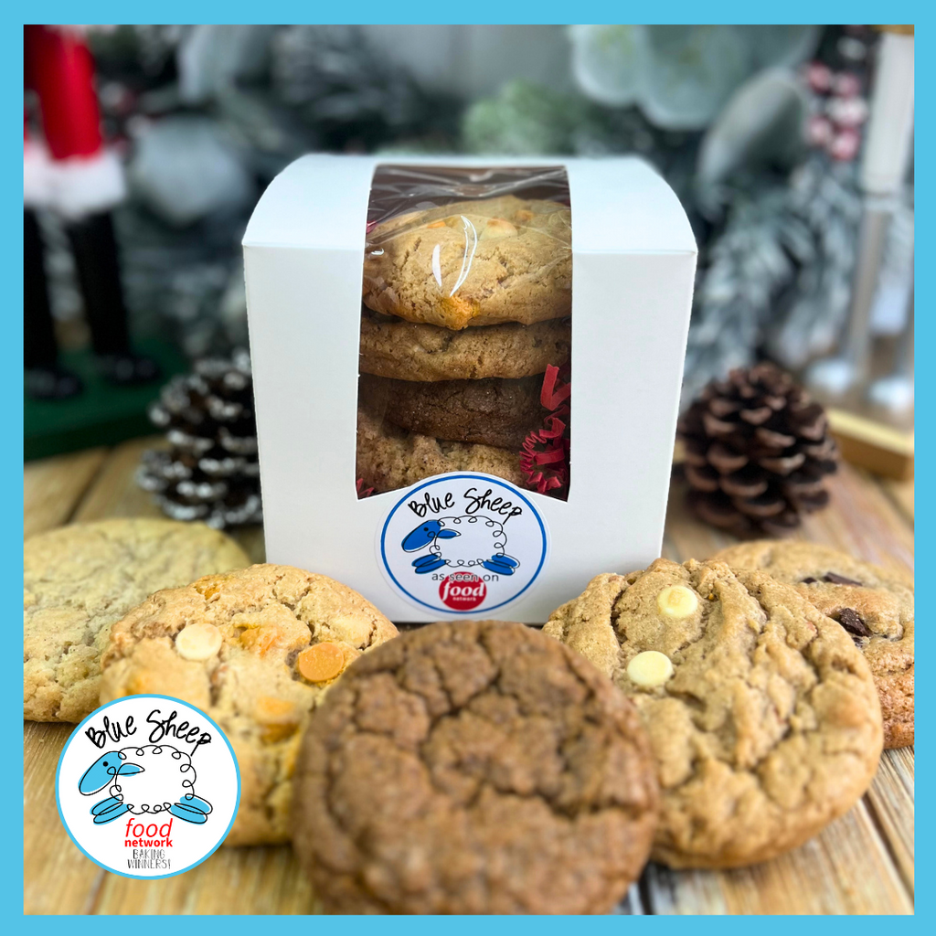 Assorted Blue Sheep gourmet cookies displayed around an open white gift box with a clear window revealing more cookies inside, all with the Blue Sheep Bake Shop logo, suggesting a delicious variety perfect for appreciation gifts.