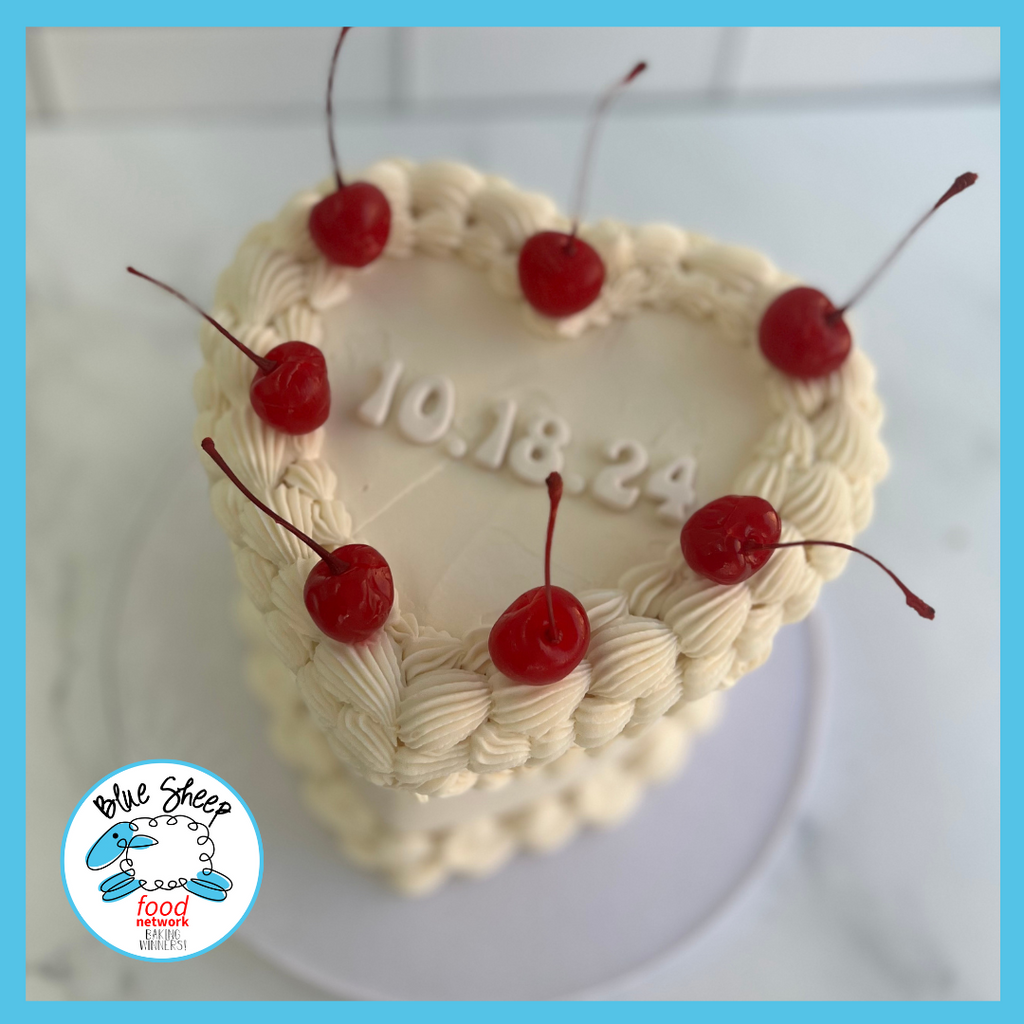 heart shaped buttercream aniversary cake with cherries