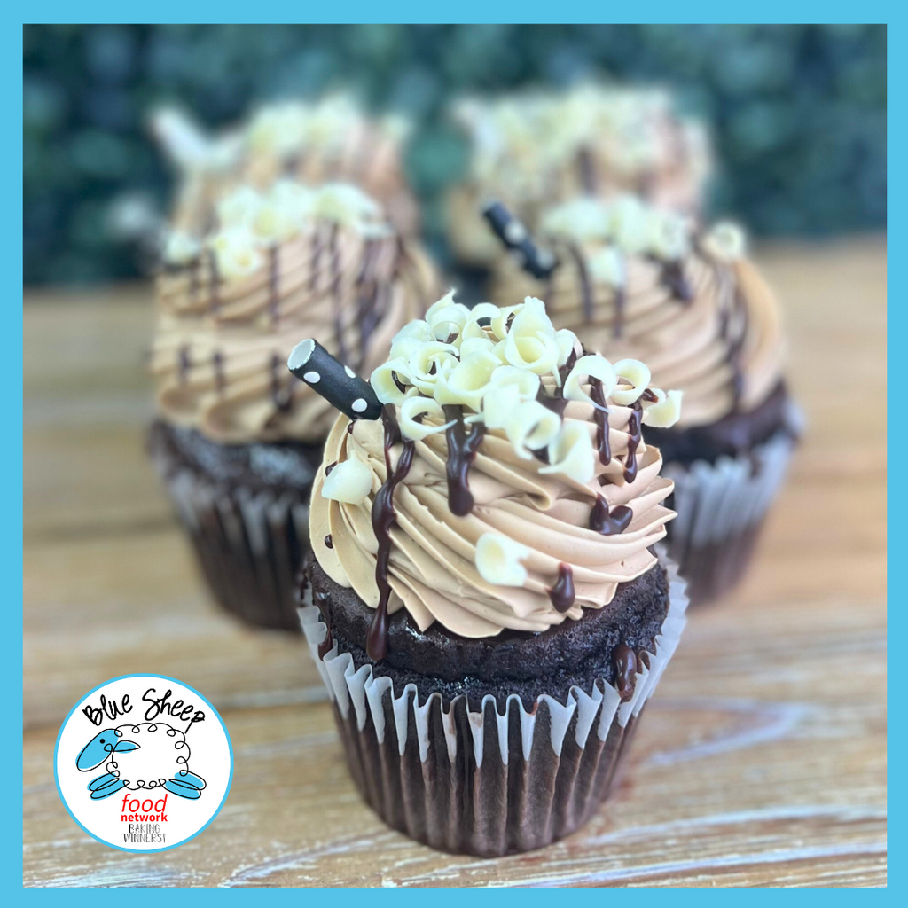 Decadent chocolate martini cupcakes with espresso liquor buttercream frosting, adorned with white chocolate curls and a drizzle of dark chocolate