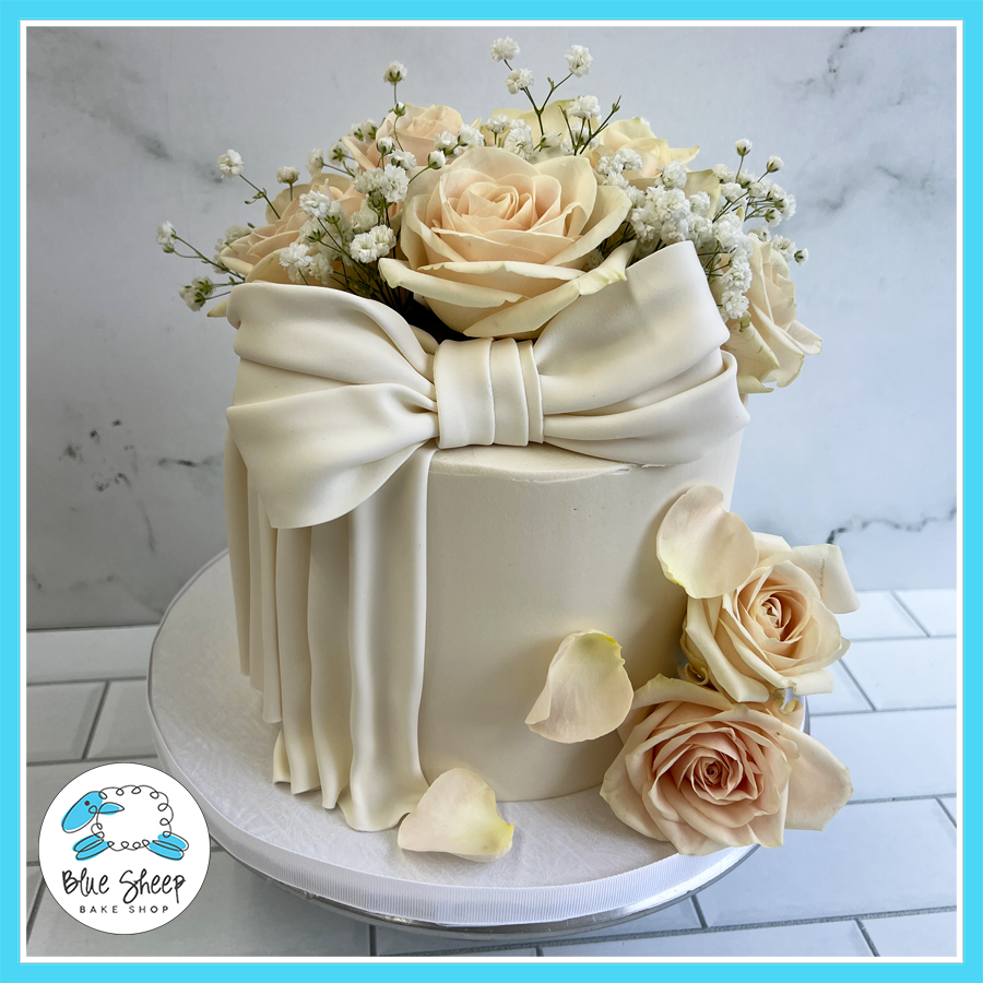 Ivory bow cake with fresh roses and draped fondant design – Blue Sheep Bake Shop Somerville NJ