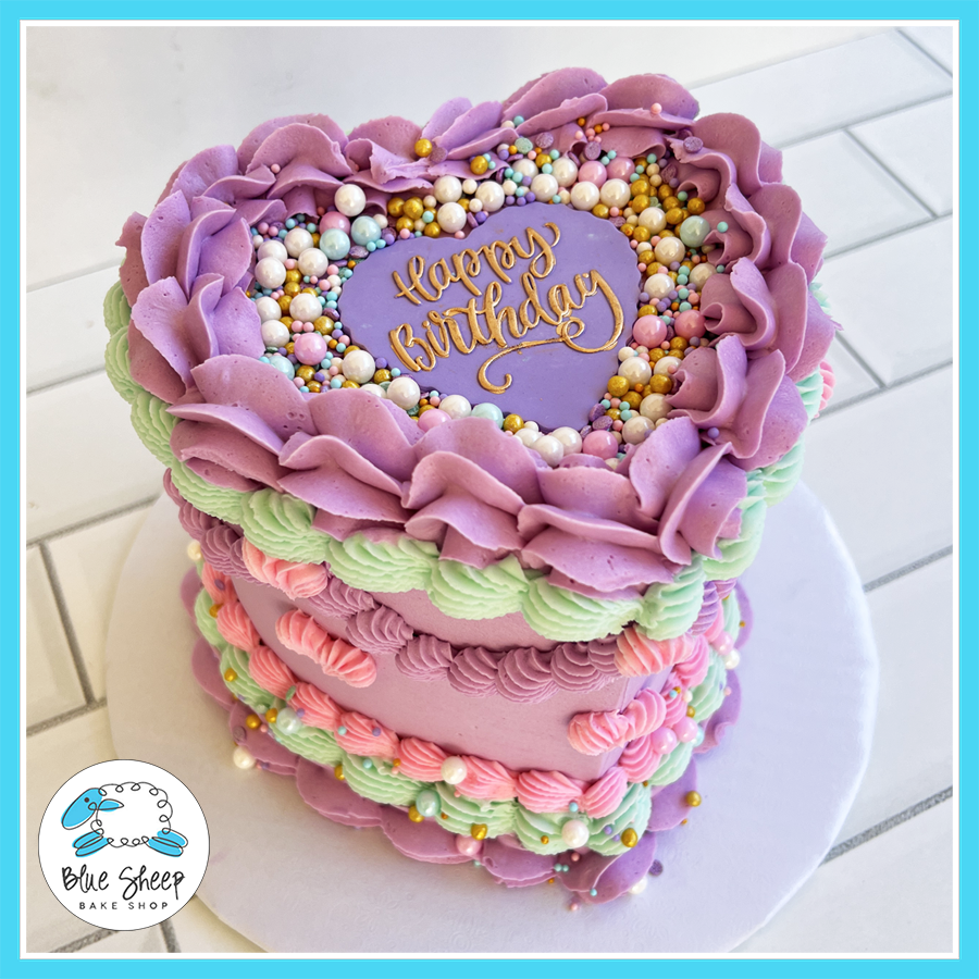 Heart-shaped birthday cake with pastel buttercream ruffles, gold sprinkles, and a vintage-inspired piped design, available at Blue Sheep Bake Shop in Somerville, NJ