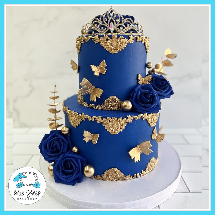 Royal blue and gold crown cake with fondant butterflies and elegant baroque decorations