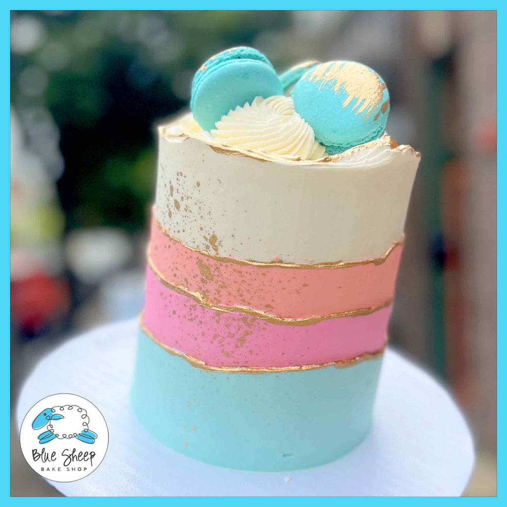 Buttercream birthday cake features waves of buttercream in blue, pink, and coral tones