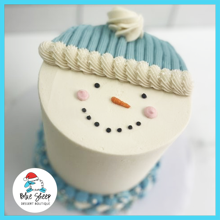 Frosty the Snowman buttercream Christmas cake with blue knit hat and smiling face from Blue Sheep Bake Shop in Somerville NJ
