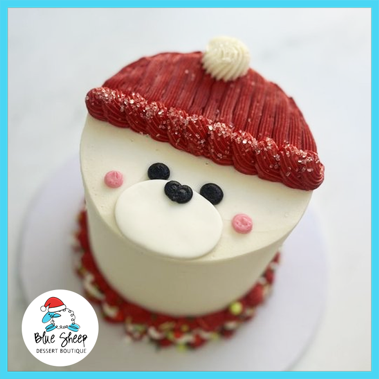 Holiday Bear Christmas Cake with buttercream bear face, red winter hat, and festive decorations made by Blue Sheep Bake Shop in Somerville NJ.
