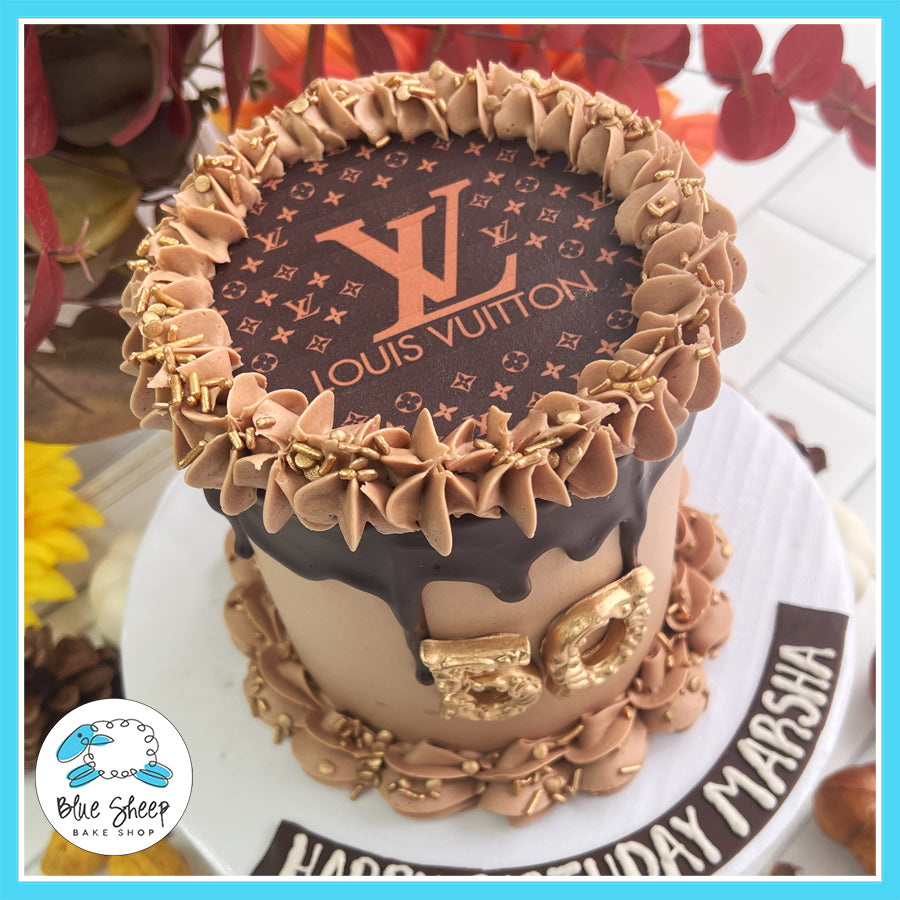 Custom Louis Vuitton-themed 50th birthday cake with chocolate drip, gold accents, and an LV logo topper by Blue Sheep Bake Shop in Somerville, NJ.