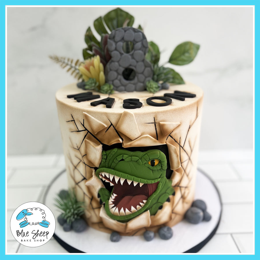 Custom T-Rex dinosaur-themed birthday cake with 3D details, edible foliage, and personalized name by Blue Sheep Bake Shop in Somerville, NJ.