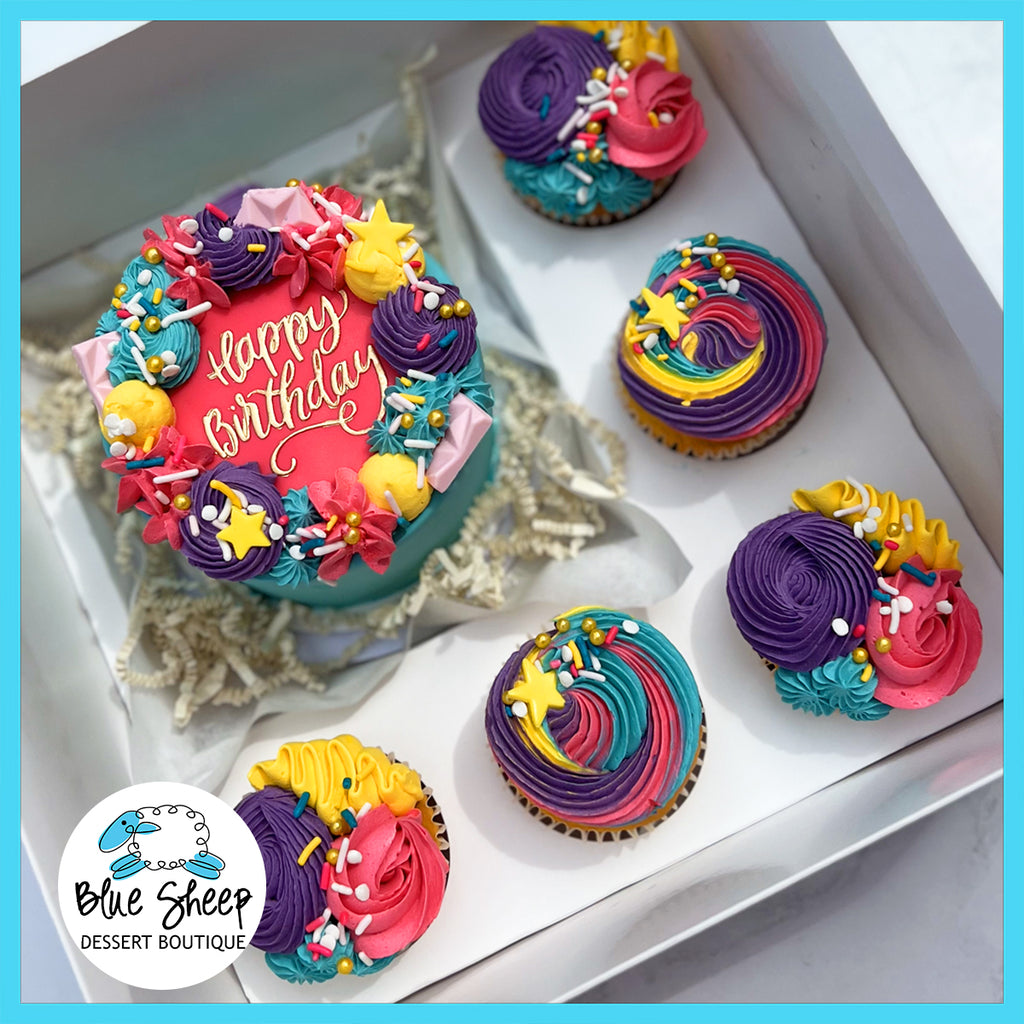 Rainbow Dreams Birthday Bento Box with a mini cake and cupcakes decorated in vibrant rainbow buttercream swirls and sprinkles order online