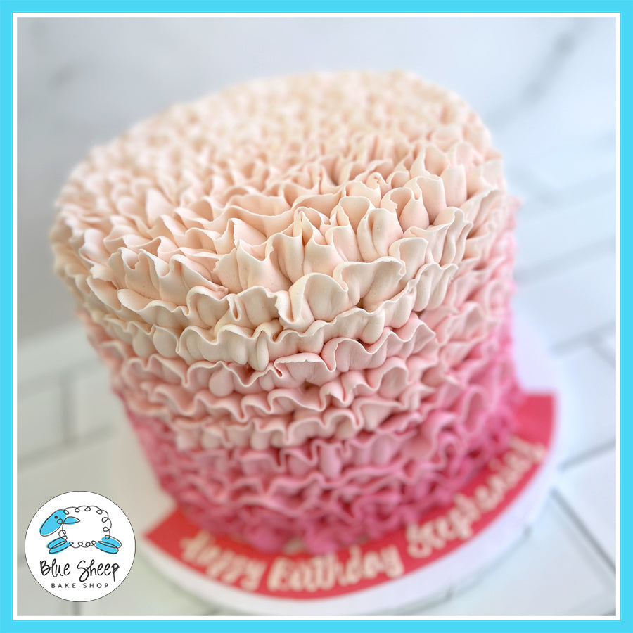 Ombre Ruffle Buttercream custom cake with pink gradient and delicate buttercream ruffles.