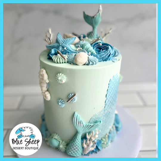 Mystical Mermaid custom birthday cake with mermaid tails, starfish, seashells, coral decorations, and blue-turquoise design.