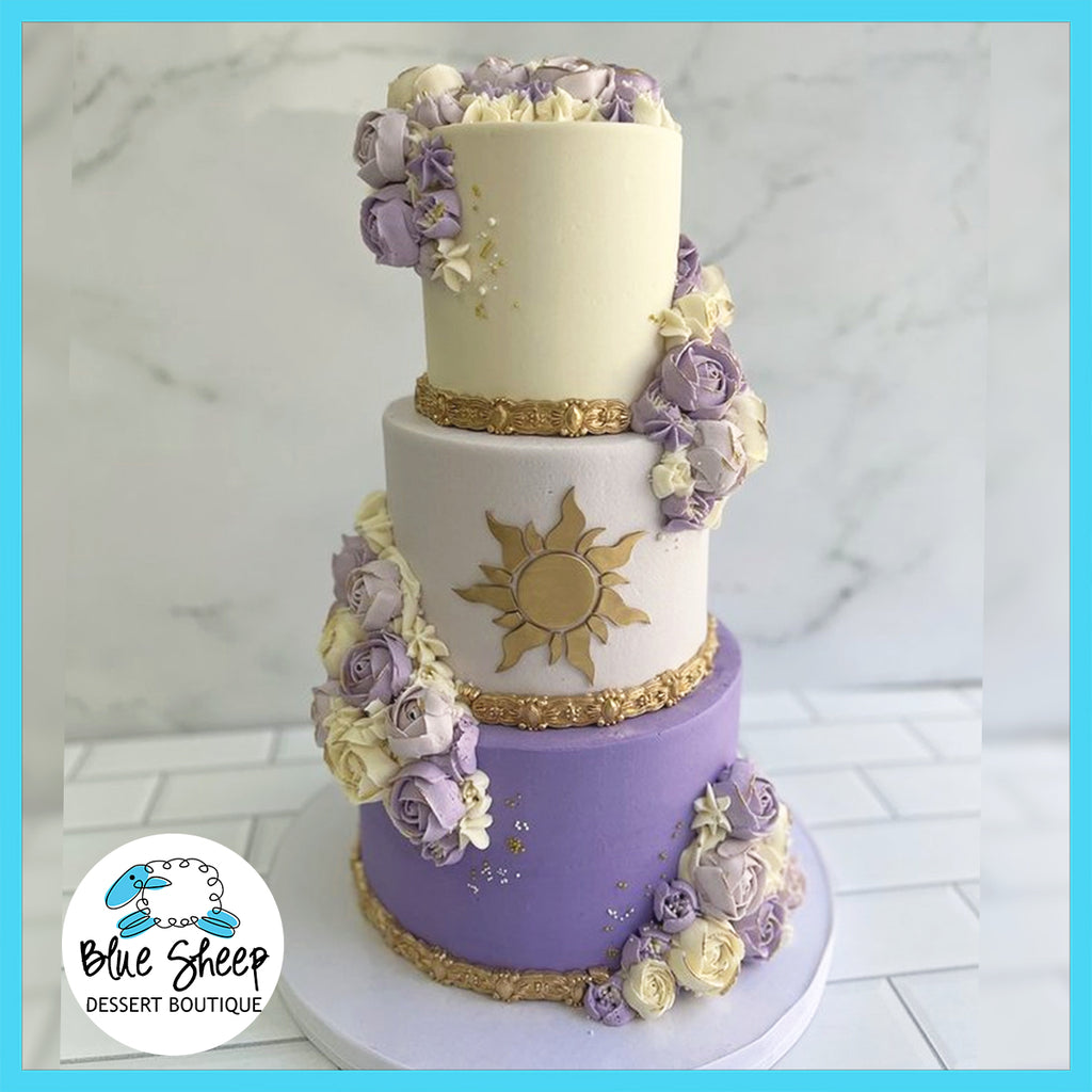 Three-tier Rapunzel-themed cake with lavender and ivory buttercream, floral decorations, and gold sun emblem