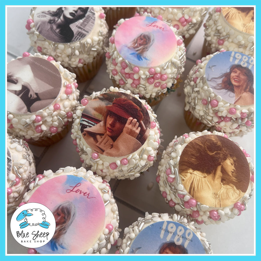 Taylor Swift-themed cupcakes with images from her albums, decorated with pink, white, and silver sprinkles.