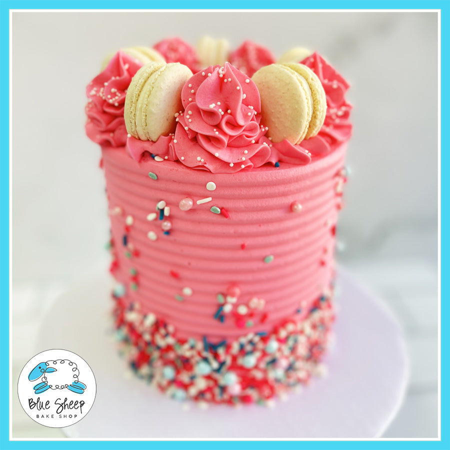 Pink textured Confetti Party cake with colorful sprinkles, macarons, and buttercream swirls by Blue Sheep Bake Shop in Somerville, NJ.