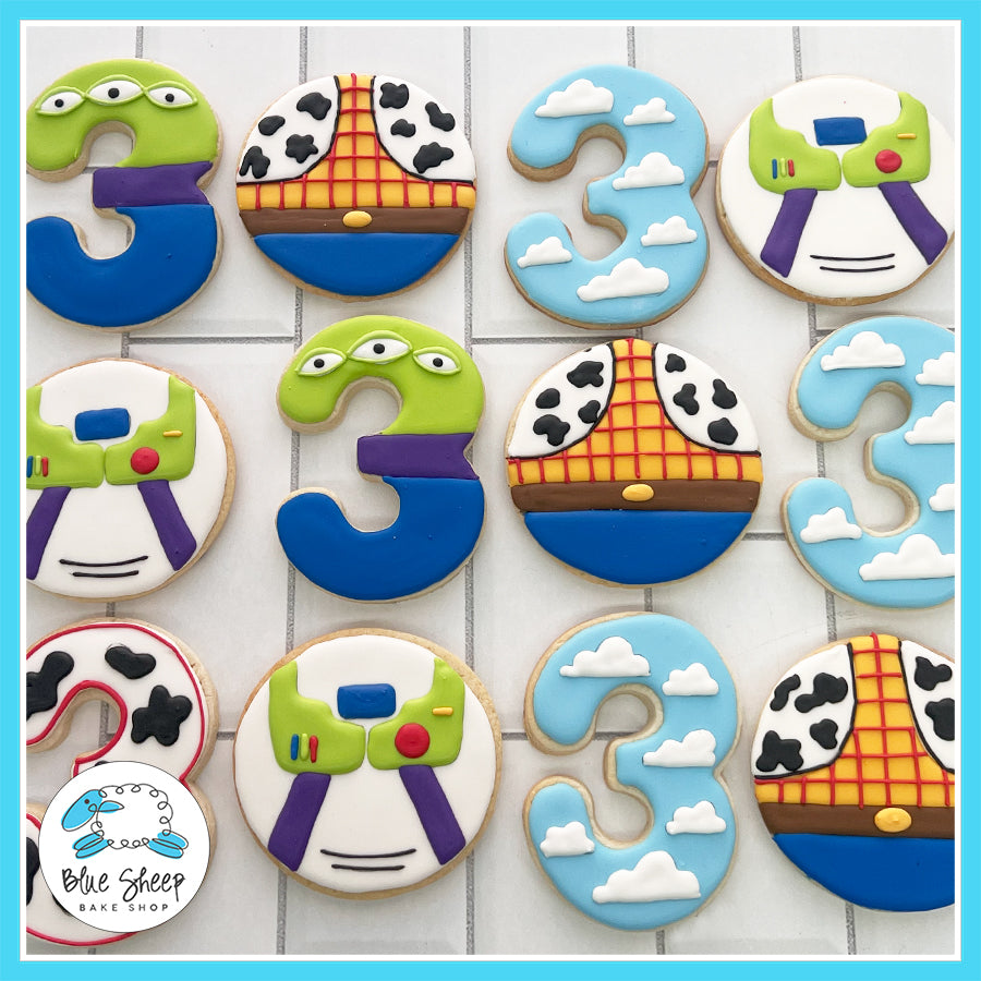 Toy Story-themed 3rd birthday cookies featuring Woody, Buzz Lightyear, Aliens, and cloud designs by Blue Sheep Bake Shop in Somerville, NJ.