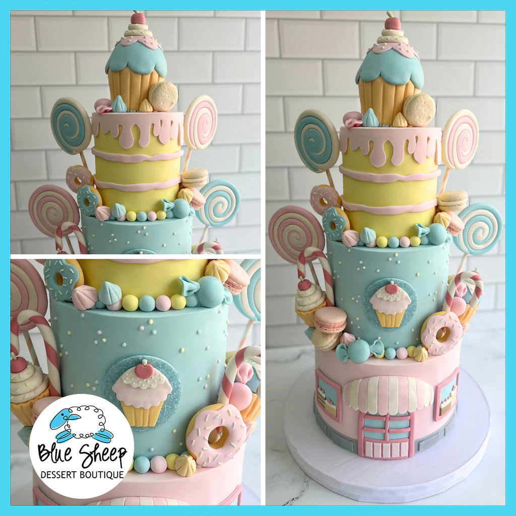 Whimsical custom birthday cake with a candy shop theme, featuring pastel colors, fondant lollipops, donuts, cupcakes, and a faux ice cream cone topping.