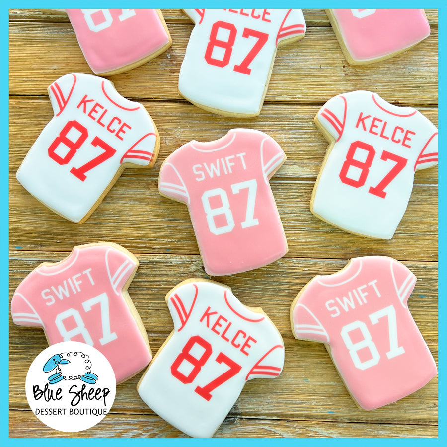Assorted pink and white jersey-shaped cookies with "Kelce" and "Swift" names and the number "87" iced on them.