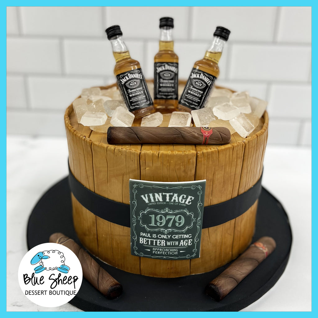 Jack Daniel's theme cake, with fondant barrel sides and fondant cigars. Mini liquor bottle toppers and isomalt ice cubes. Only getting better with age!