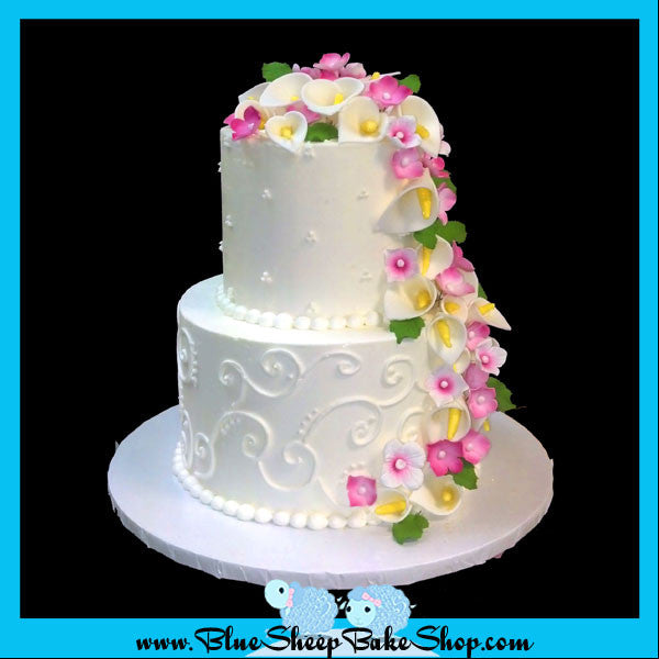 classic butter cream buttercream wedding cake with cascading calla lillies and magenta hydrangea