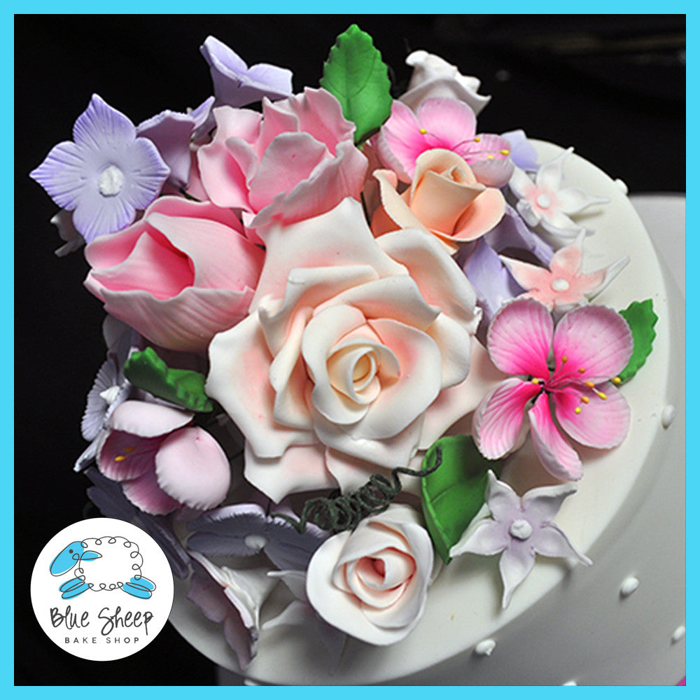 wedding cake with roses, stephanotis, hydrangea, and cherry blossoms