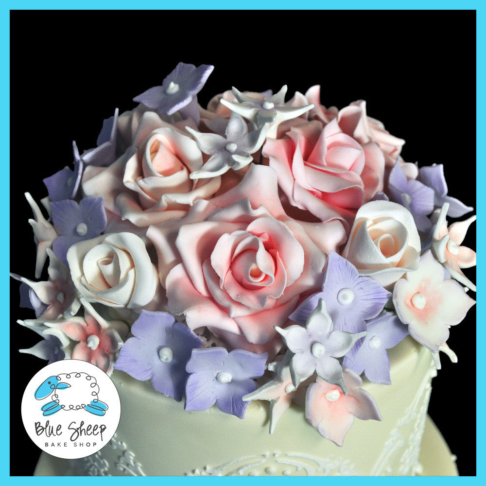 wedding cake with pink sugar roses, white stephanotis, lavender hydrangea